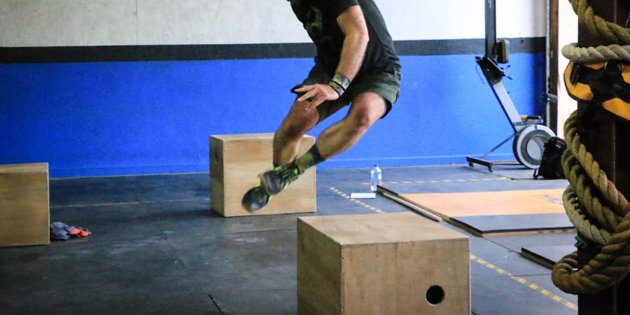 Homem pulando box jump.